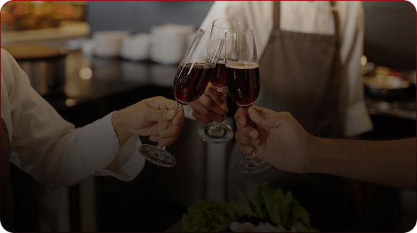 friends clinking glasses of red wine across a table