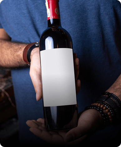 person presenting a wine bottle with a blank white label