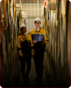 two warehouse workers standing between storage racks